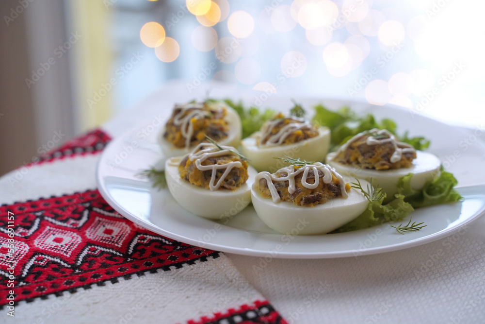 Deviled eggs aka stuffed eggs. Traditional Ukrainian food on the table with embroidered tablecloth.
