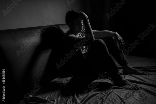 Man with depression sitting in a dark room.  Depression is a low mood that lasts for a long time, and affects your everyday life.