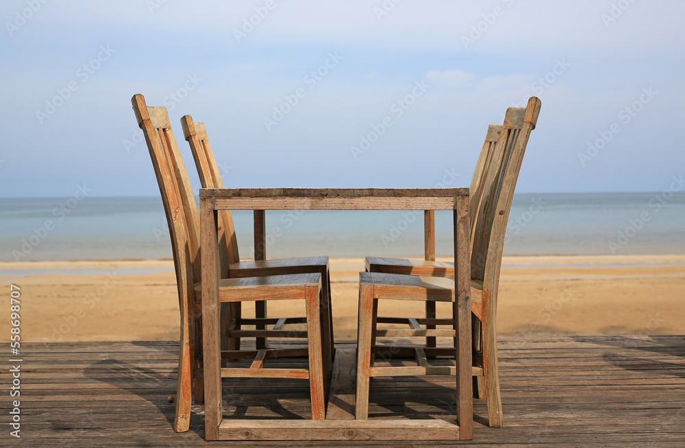 Empty wood table and chairs at restaurants near the beach.