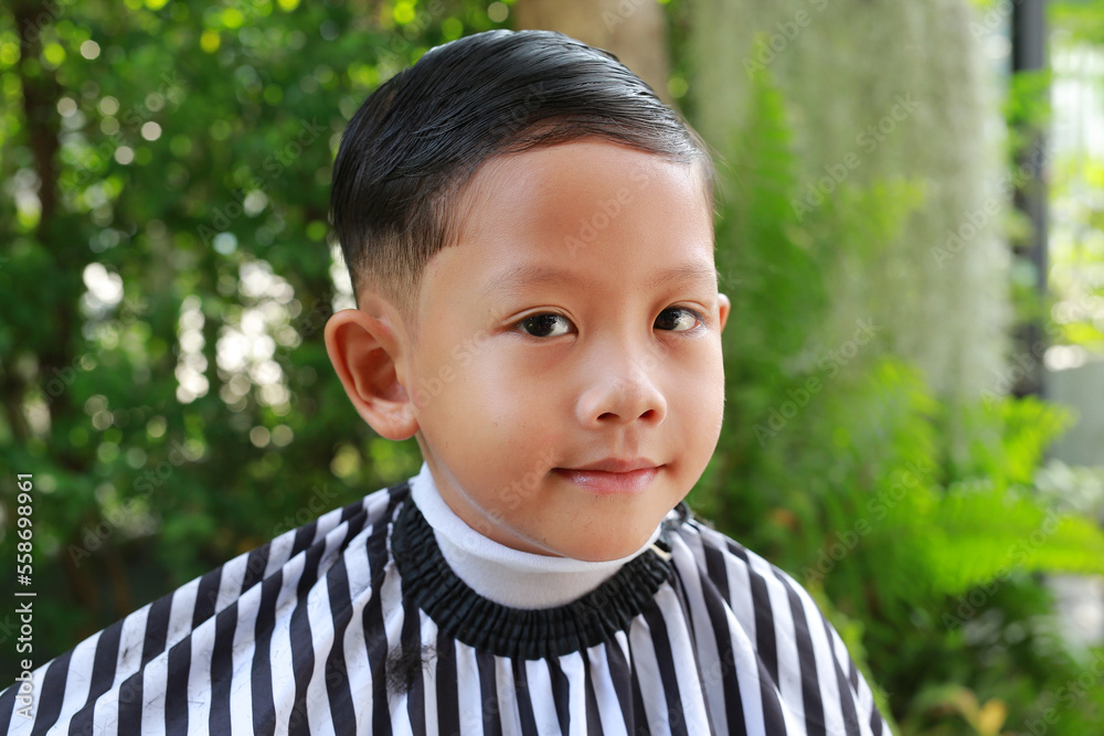 Portrait of Asian boy cut in haircut in the garden, fashion haircut for a guy.