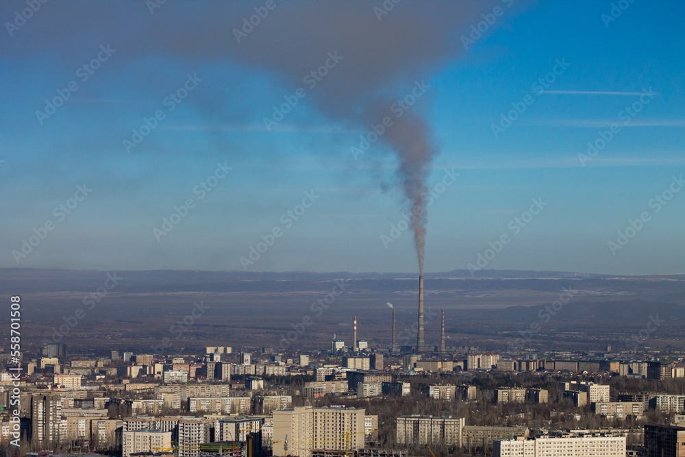 smoke from burning coal in a heat and power station comes out of the chimney and settles over the city