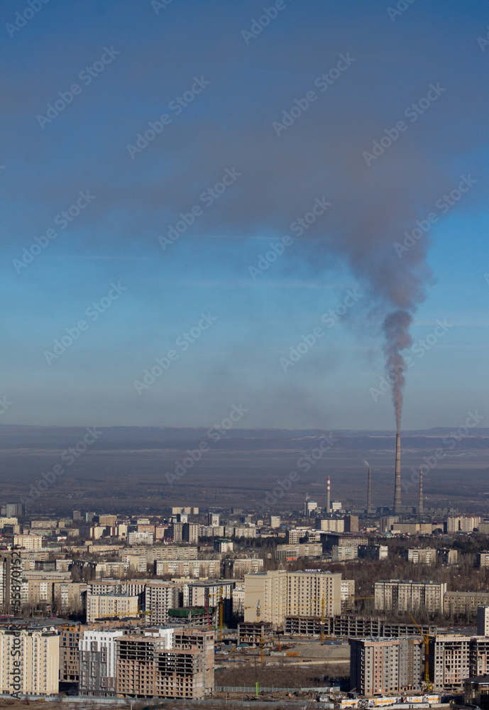 smoke from burning coal in a heat and power station comes out of the chimney and settles over the city