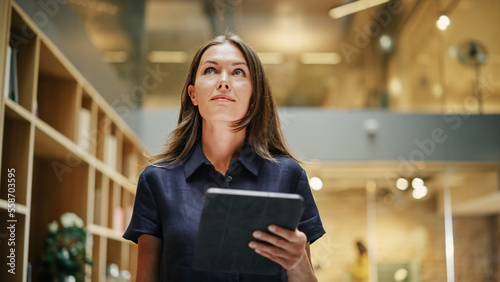 Foto Close Up of a Content Female CEO Making Notes on her Tablet