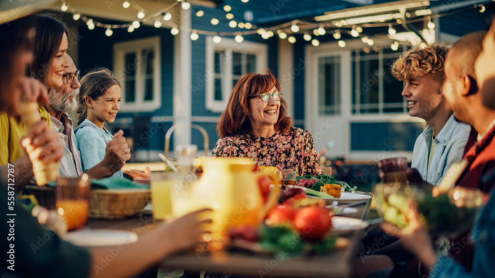 Parents, Children, Relatives and Friends Having an Open Air Barbecue Dinner in Their Backyard. Old and Young People Talk, Chat, Have Fun, Eat and Drink. Garden Party Celebration in a Backyard.