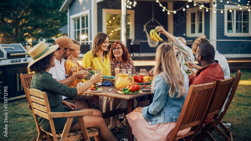 Big Family and Friends Celebrating Outside in a Backyard at Home. Diverse Group of Children, Adults and Old People Gathered at a Table, Having Fun, Eating Vegan Meals.