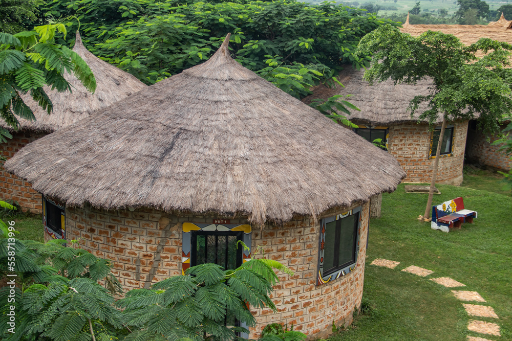 African lodge for tourists, with round shaped traditional houses called Tukul, with colorful benches around, made of natural materials, environmental friendly