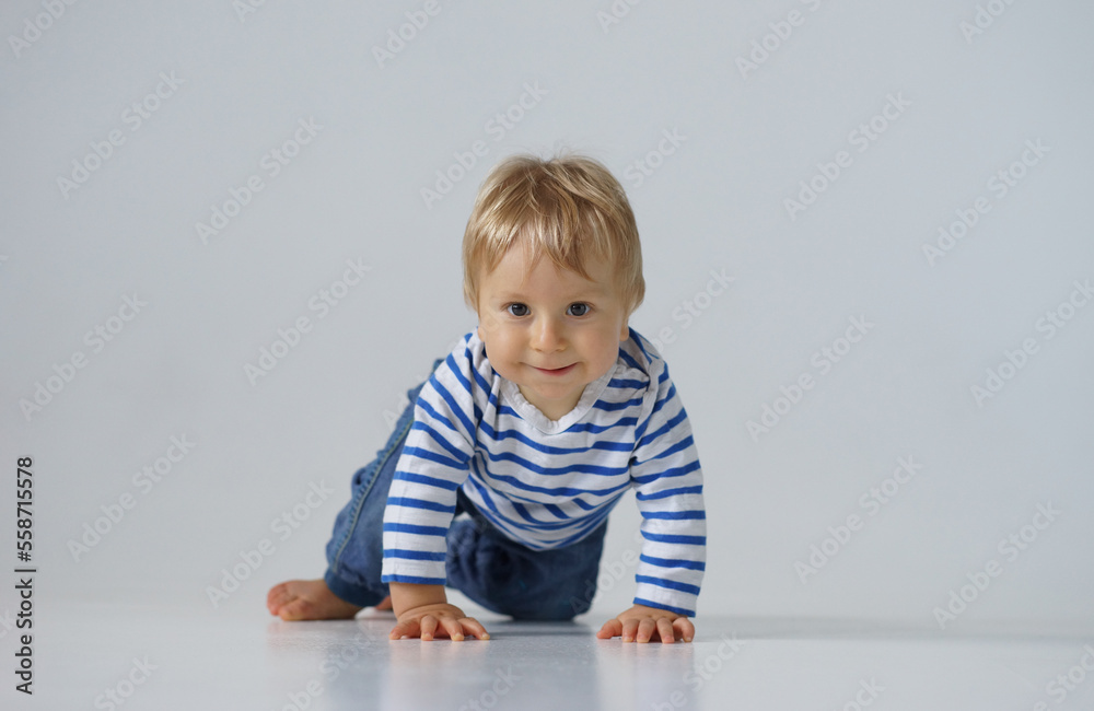 Little, happy and smiling cute baby in the studio. Portrait of a one year old baby. The concept of happiness. Little, happy and smiling cute baby in the studio. Portrait of a one year old baby. The concept of happiness.