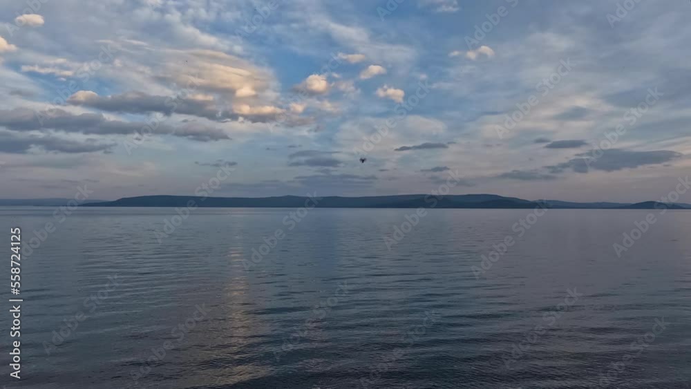 Majestic view of lake Khovsgol with beautiful mountains in the background. Blue water edge with the misty looking sky in the horizon. Majestic view of lake Khovsgol with beautiful mountains in the background. Blue water edge with the misty looking sky in the horizon.