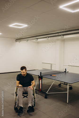 A boy in a wheelchair plays table tennis.