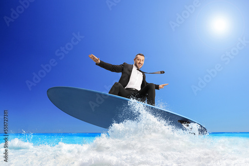 Businessman riding a surfboard on a sea wave