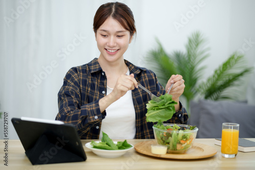 Portrait of happy playful asian girl eating fresh salad  in diet concept