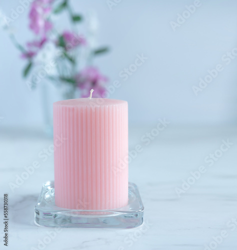 unlit pink candle on floral background