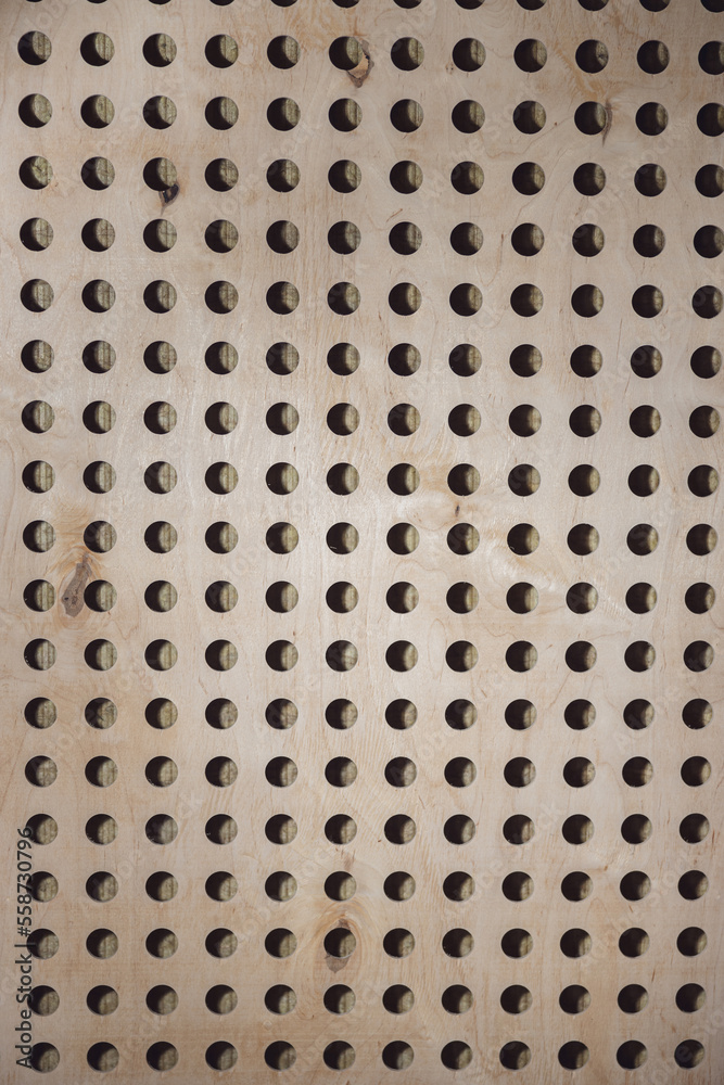 Wooden wall with round holes. Texture, pattern, background. Element of soundproof room in broadcast and sound recording studio Wooden wall with round holes. Texture, pattern, background. Element of soundproof room in broadcast and sound recording studio