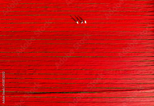 Aerial view of people working in a field stretching red cotton fabric rolls in Narsingdi, Dhaka, Bangladesh. photo