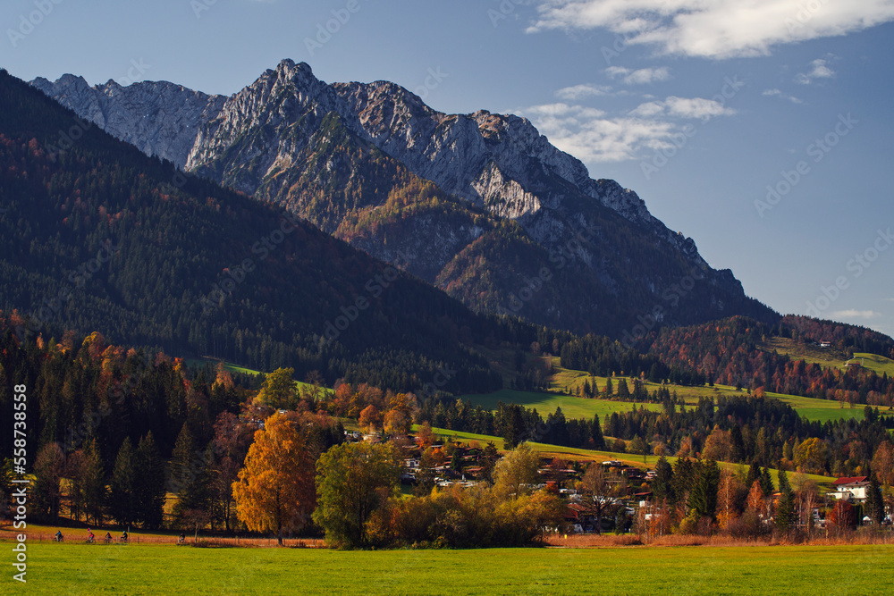 Herbststimmung in der Abendsonne im Kaisergebirge in den österreichischen Alpen mit Blick auf ein Tal und einem Berg in mystischem Licht