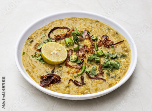 Chicken haleem with fried onion and lemon served in plate isolated on table top view of indian and pakistani spicy food
