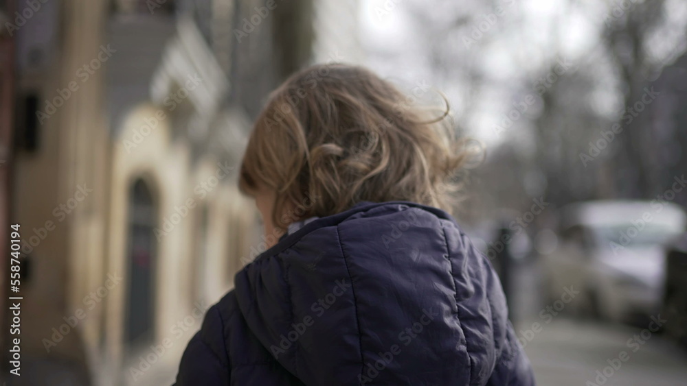Back of toddler walking in city sidewalk during winter2 Back of toddler walking in city sidewalk during winter2