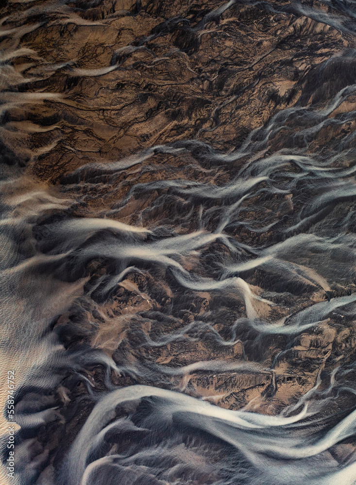 Aerial view of abstract water formation from a river estuary at Holtsos lake along the coast, Iceland. Aerial view of abstract water formation from a river estuary at Holtsos lake along the coast, Iceland.