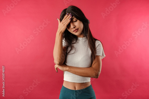 Young caucasian woman wearing casual top isolated over red background feeling bad sick covering forehead with hand. Touching forehead having headache migraine or depression, upset frustrated troubled. © platinumArt