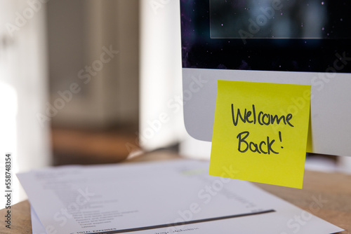 Welcome back post it note on computer, yellow sticky note, office welcome back note