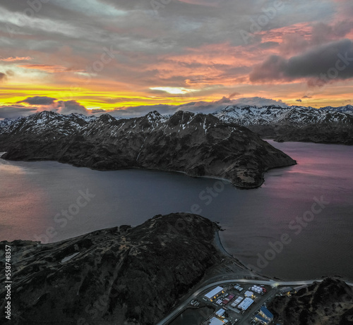 Aerial view of a mountain range with snow on the crests along the Dutch Harbour on Amaknak Island at sunset, Unalaska, Alaska, United States. photo