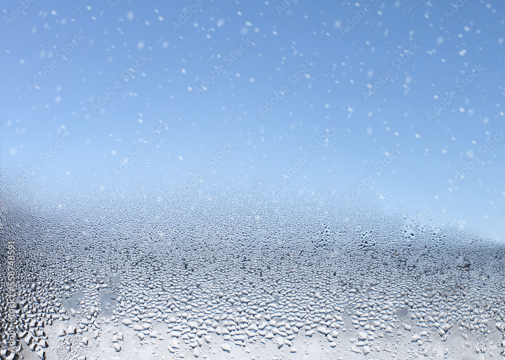 Water drops and snow on the wet window glass. Abstract background. Water drops and snow on the wet window glass. Abstract background.