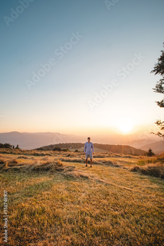 Man in shirt watching sunset on a mountain in Beskydy mountains  Czech republic. Soaking up positive energy and relieving stress. Feeling yourself
