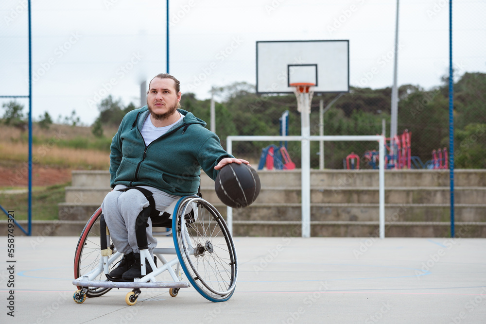 athlete in wheelchair practicing dribbling movement in basketball court