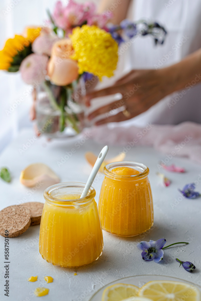 Lemon curd in glass jars decorated with spring flowers and pastels Lemon curd in glass jars decorated with spring flowers and pastels