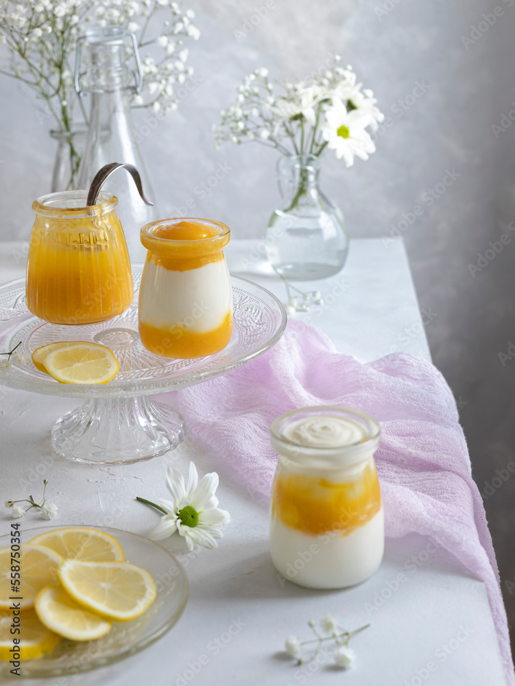 Lemon curd and greek yogurt with thyme in glass jars. Soft romantic scene. Lemon curd and greek yogurt with thyme in glass jars. Soft romantic scene.