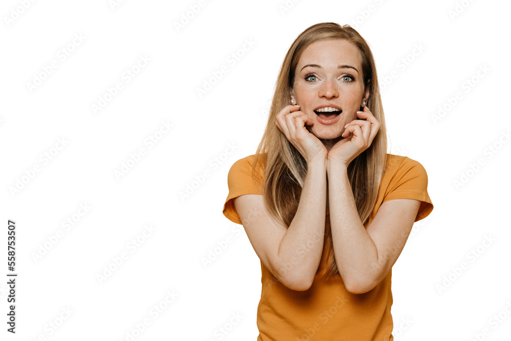 Amazed cheerful redhead woman with wondered face, touching her face in surprise, shocked by discount, wears yellow clothes, poses over transparent background with copy space. People sincere emotions