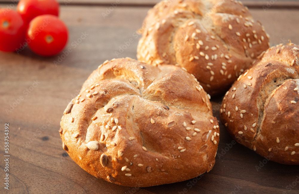 Bread rolls with seeds on wooden background.