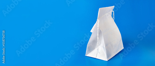 Paper bag sewn with thread on a blue background. Packaging of food products.