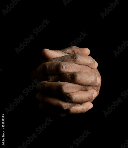 man praying to god with hands together Caribbean man praying on white background with people stock photo