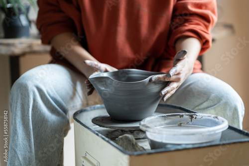 Art as meditation. Ceramic master shaping bowl on pottery wheel, cropped photo. Woman creating pieces from clay while visiting ceramics masterclass, crafting pot by hand. Creative hobbies concept