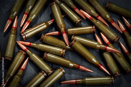 Ammunition for a automatic rifle on dark surface. Cartridges to AK 74.
