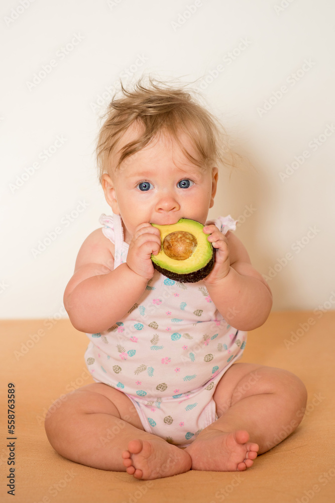 little girl eating a fruit. Little child eats an avocado little girl eating a fruit. Little child eats an avocado