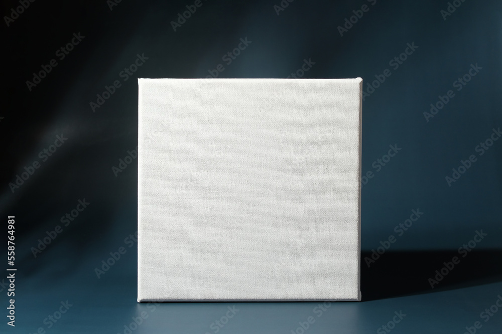 Blank square canvas frame on dark blue background Blank square canvas frame on dark blue background