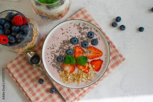 Yogurt, chia seeds, blueberries, strawberries, raspberries, mint on a light background