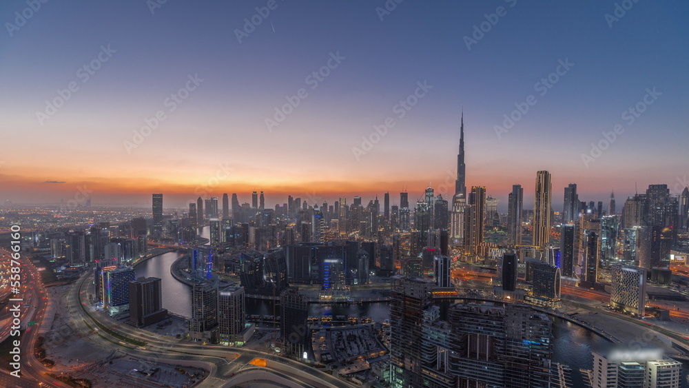 Naklejka premium Skyline with modern architecture of Dubai business bay towers day to night timelapse. Aerial view