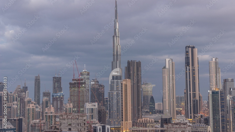 Panoramic skyline of Dubai with business bay and downtown district night to day timelapse.