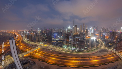 Panoramic skyline of Dubai with business bay and downtown district night to day timelapse.