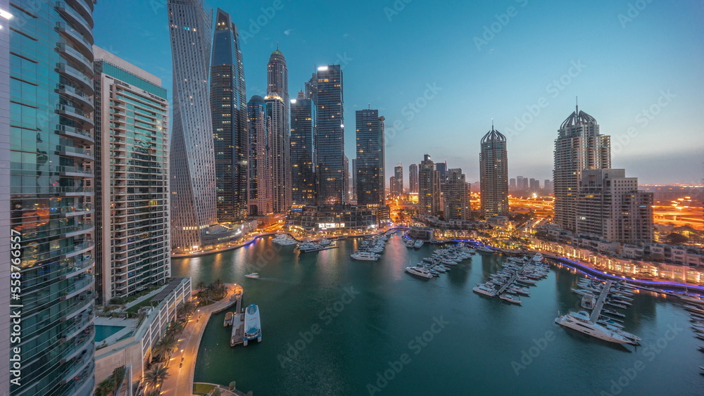 Fototapeta premium Dubai marina tallest skyscrapers and yachts in harbor aerial night to day timelapse.