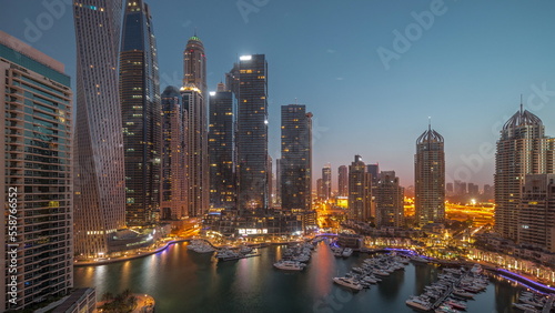 Dubai marina tallest skyscrapers and yachts in harbor aerial night to day timelapse. © neiezhmakov