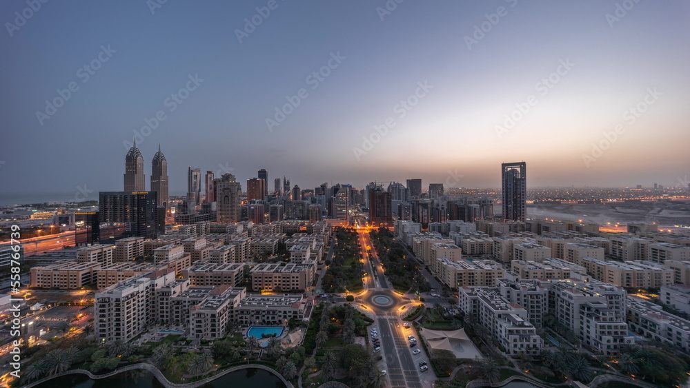 Panorama of skyscrapers in Barsha Heights district and low rise buildings in Greens district aerial night to day timelapse.