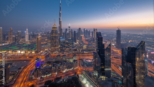 Aerial view of tallest towers in Dubai Downtown skyline and highway day to night timelapse.