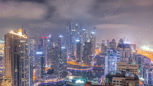 View of various skyscrapers in tallest recidential block in Dubai Marina aerial all night timelapse