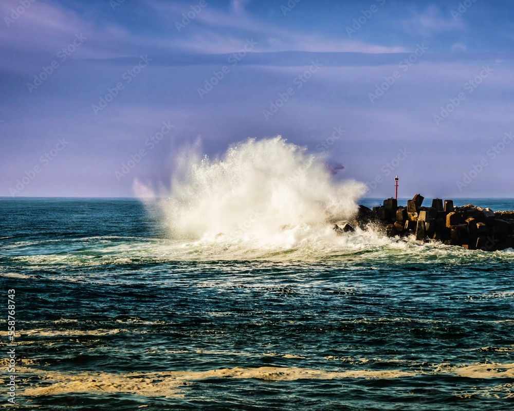 Wave crashes into breakwater