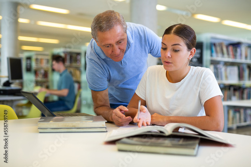 A mature male tutor teaches a young Caucasian student. High quality photo