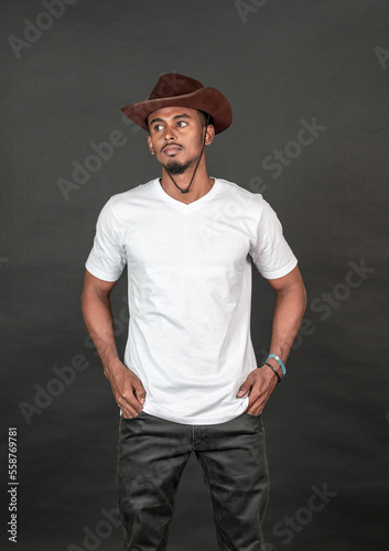 A young handsome man wearing white blank shirt, doing a simple pose with both of his hand on his pocket